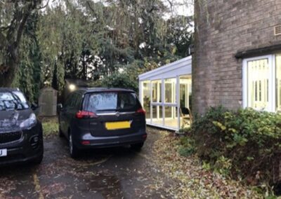 outside one of our services showing two black cars and part of the building extension