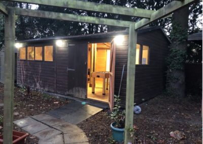 Showing lit up outside shed that is nicely decorated with lights
