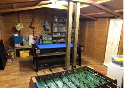 Inside the shed showing a Foosball table and pool/snooker table with other trinkets in the background