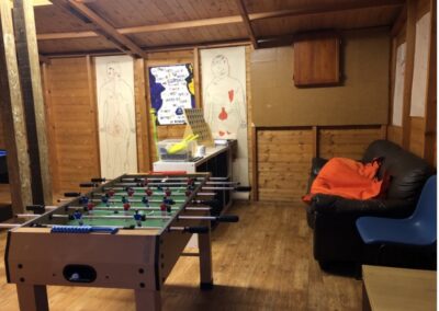 On the left is a foosball table and on the right is a comfy seat