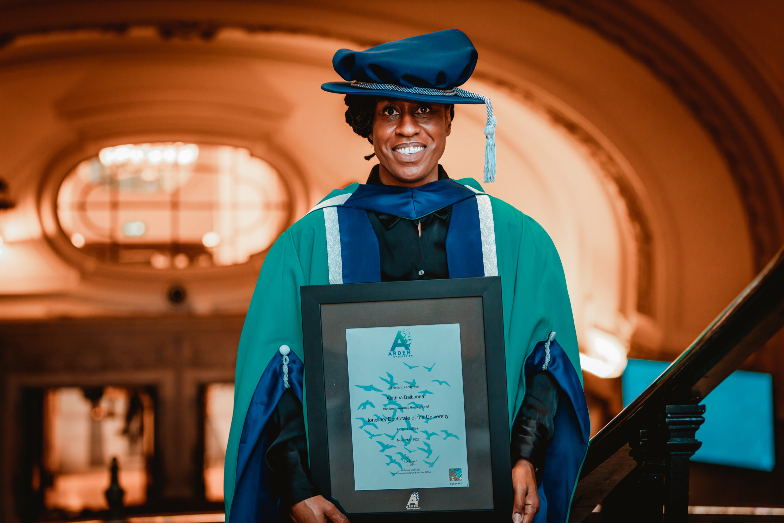 Woman holding a certificate in a graduation cap and gown
