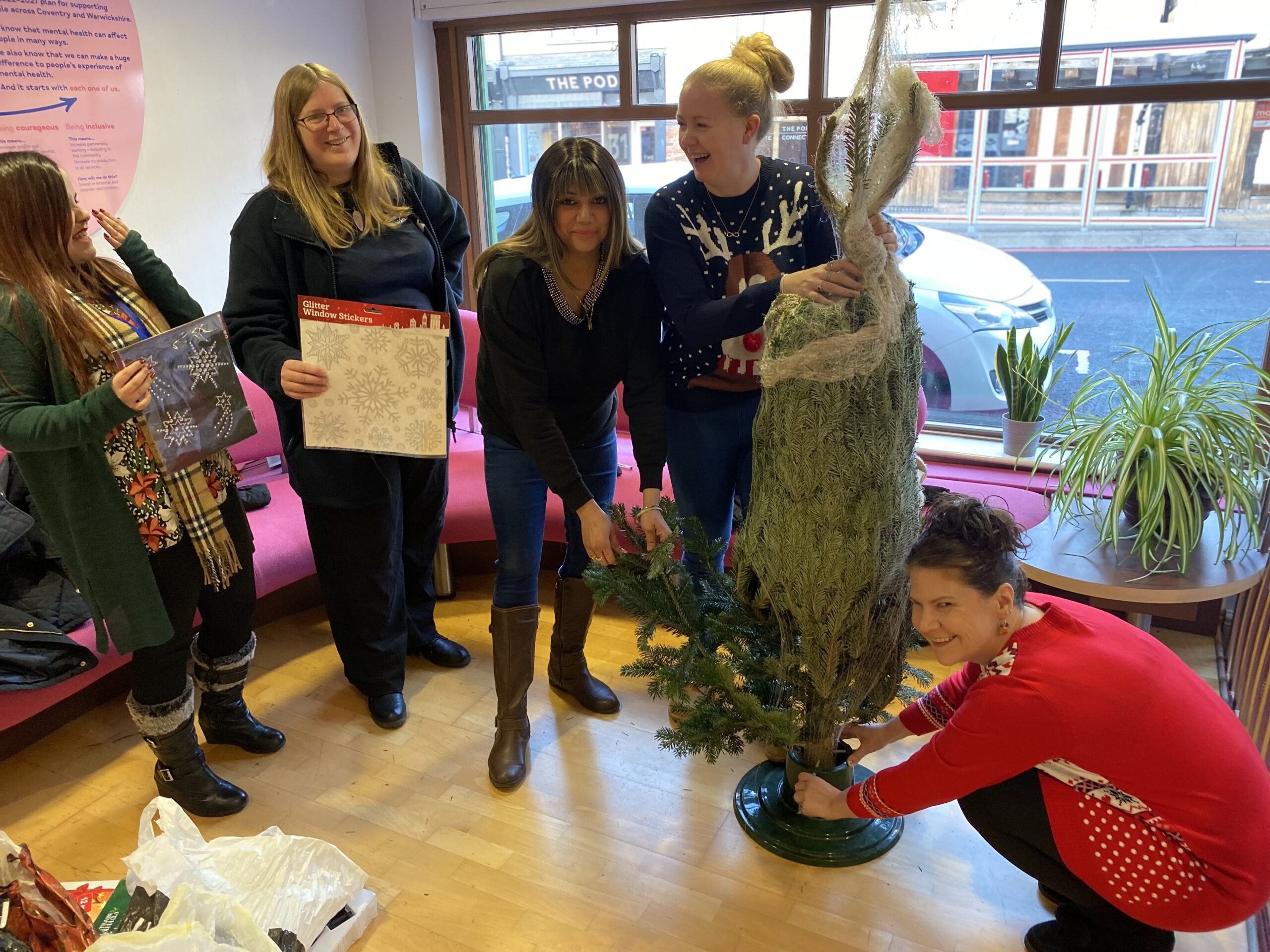 Five woman holding a real Christmas tree