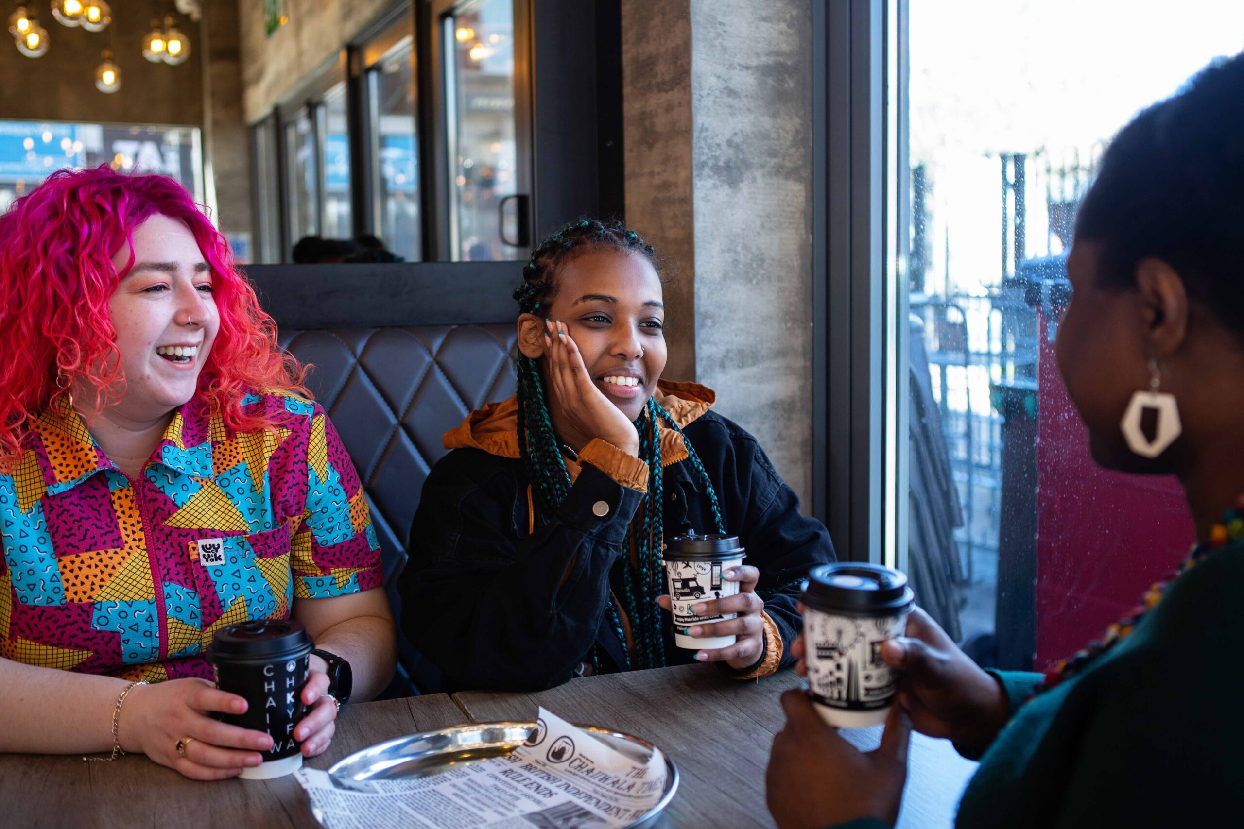 A group of female friends in a cafe drinking coffee and chatting.
