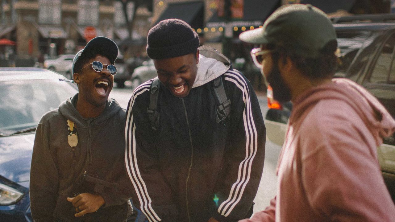 Three young Black men laughing and chatting