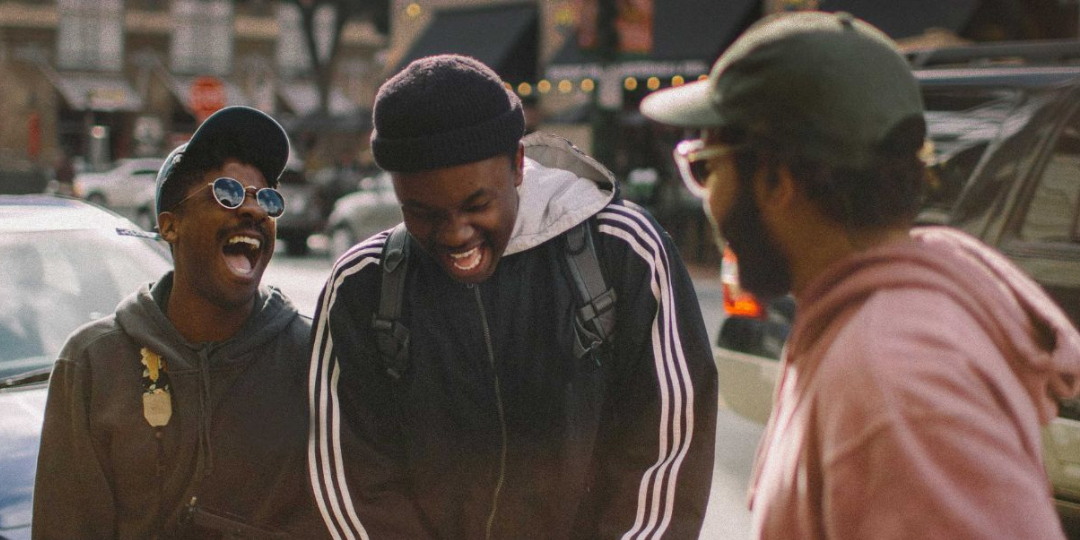 Three young Black men laughing and chatting